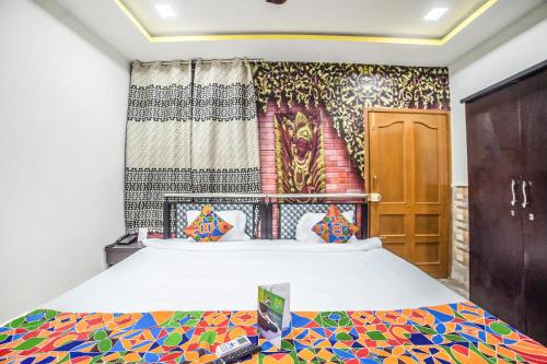 1 dormitorio con 1 cama con una pintura en la pared en FabHotel ABC View, en Indore