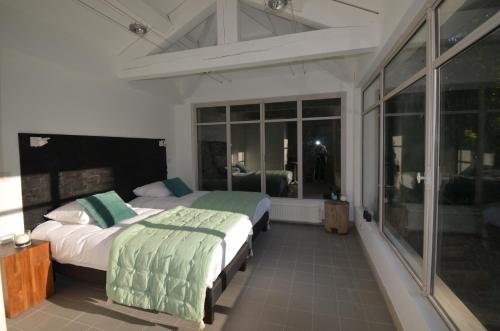 een slaapkamer met 2 bedden en een groot raam bij Domaine Shambala - Piscine Naturiste in Velaux