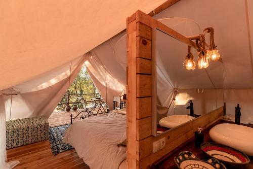 a bedroom in a tent with a bed and a sink at Plage Cachée - Glamping in Vrboska