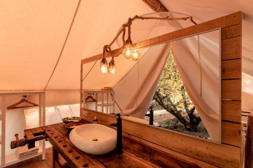 Plage Cachée - Glamping في فربوسكا: حمام مع حوض ومرآة كبيرة