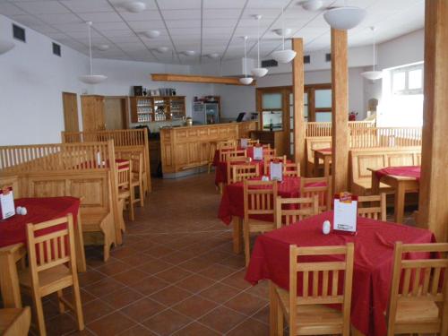 スピンドレルフ・ムリンにあるHorská chata Sedmidolíの木製テーブルと椅子(赤いテーブルクロス付)のあるレストラン