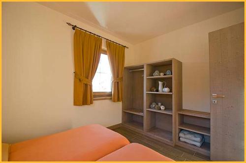 a bedroom with an orange bed and a window at Mery Livigno in Livigno