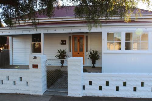 
a white house with two windows and a white fence at Signature on Gunn in Devonport
