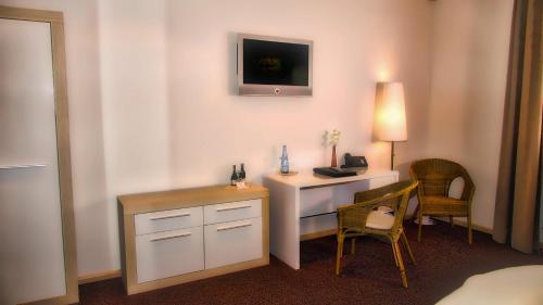 a hotel room with a desk and a table and chairs at Fritz Hotel & Restaurant KG in Weil am Rhein