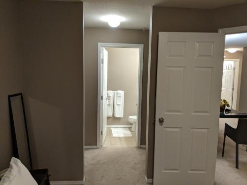 a bathroom with a white door and a toilet at Quiet 2 Bed 2 Bath close to Westview Hospital in Stony Plain