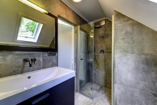W łazience znajduje się prysznic i umywalka. w obiekcie Buitenplaats Gerner w mieście Dalfsen