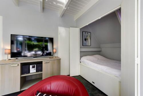 a small bedroom with a bed and a flat screen tv at Buitenplaats Gerner in Dalfsen