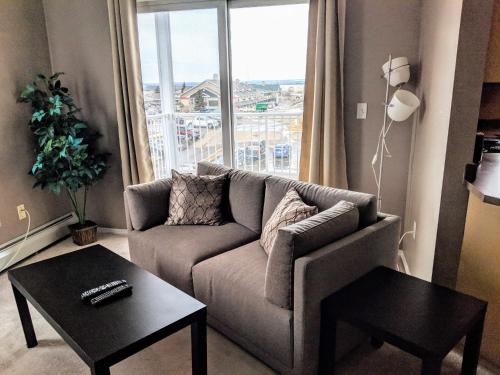 a living room with a couch and a large window at Quiet 2 Bed 2 Bath close to Westview Hospital in Stony Plain