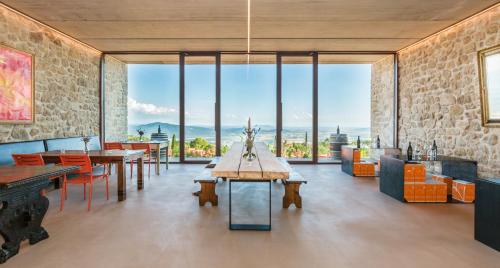a room with tables and chairs and large windows at VALDONICA WINERY Fine Dine & Wine Hotel in Sassofortino