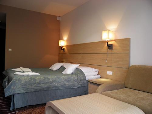 a hotel room with two beds and a chair at Phoenix in Kołobrzeg