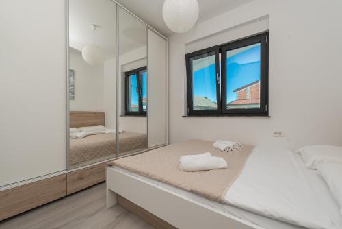 a bedroom with a bed and a mirror at Luxury Apartments VilaMaloca in Vir