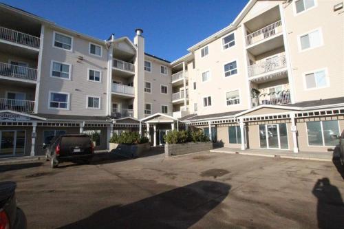 a parking lot in front of a large apartment building at Quiet 2 Bed 2 Bath close to Westview Hospital in Stony Plain