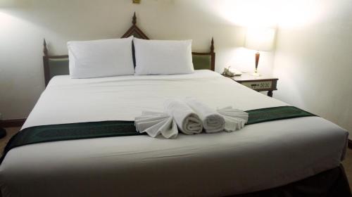 a bed with white sheets and towels on it at JP Emerald Hotel in Yasothon