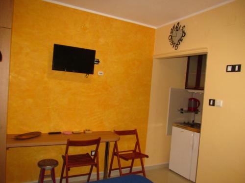 a room with a table and chairs and a television on the wall at Apartment 9 Gorska Vila in Zlatibor