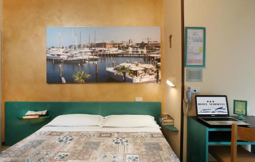 una camera con letto e scrivania con computer portatile di Hotel Marselli a Rimini