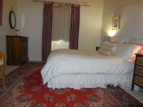 Un dormitorio con una cama grande y una alfombra roja en Sandalmere Cottage en Cadell