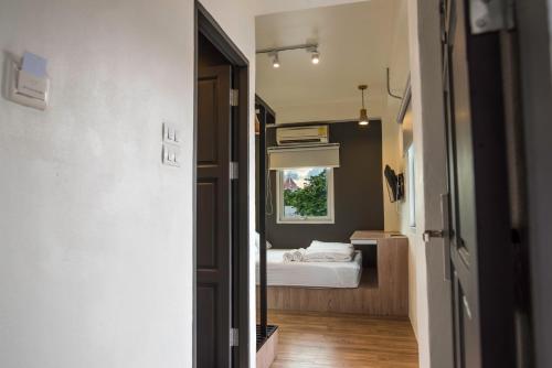 a room with a bed and a bedroom with a window at Jam Hostel Bangkok in Bangkok