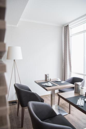 a living room with a table and chairs at Hotel Novostar in Göttingen