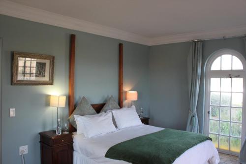 a bedroom with a large bed and a window at Hawksmoor House in Stellenbosch