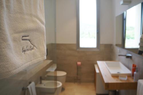 a bathroom with a sink and a toilet and a towel at B&B Capo Torre Resort & SPA in Albisola Superiore