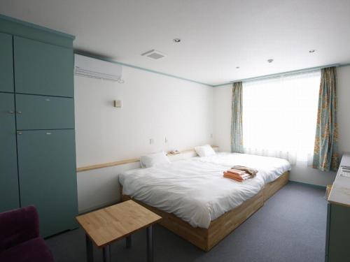 a bedroom with a bed and a window at Awajishima Hotel Lodge GREEN COZY in Minamiawaji
