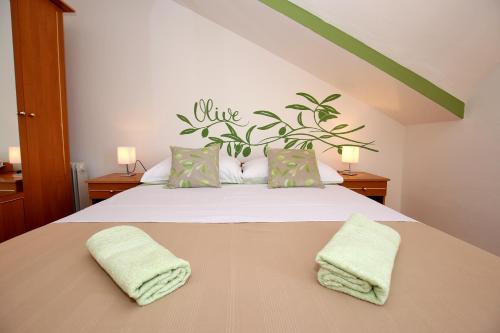 ein Schlafzimmer mit einem Bett mit zwei Handtüchern darauf in der Unterkunft Apartments Mara in Zadar