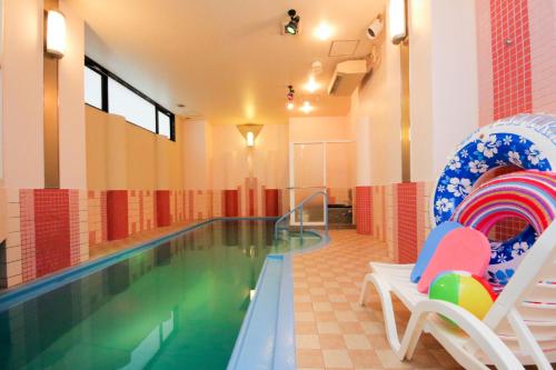 una piscina con 2 sillas y una piscina en Hotel Luna Coast (Adult Only) en Otaru