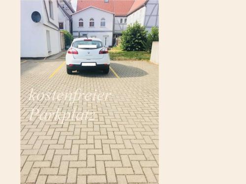 a white car parked in a parking lot at Gaestehaus _ Sandra Objekt _ 90541 in Bützow