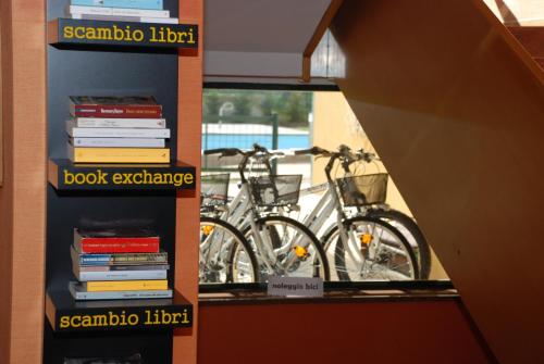 a book shelf with books and a bike on it at Hotel La Pergola in Grezzana