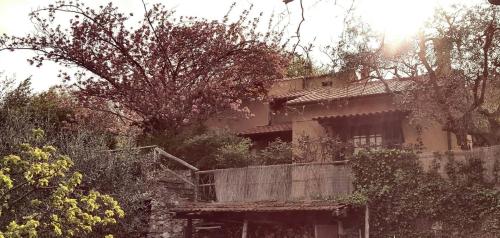 uma casa velha com uma cerca de madeira em frente em L'Uliveto D'Argento em Finale Ligure