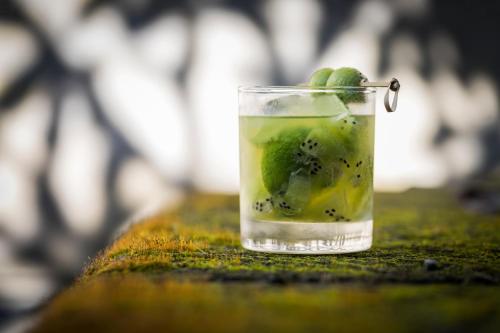 a drink with kiwi and kiwis in a glass at REVĪVŌ Wellness Resort Nusa Dua Bali in Nusa Dua
