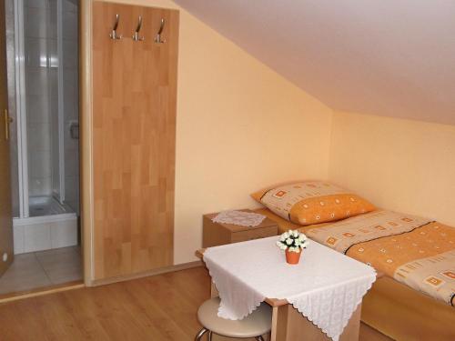 a room with two beds and a table and a shower at Windstille in Oščadnica