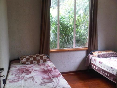 Habitación con ventana, cama y asiento de ventana en Sleek Hostel, en Johannesburgo