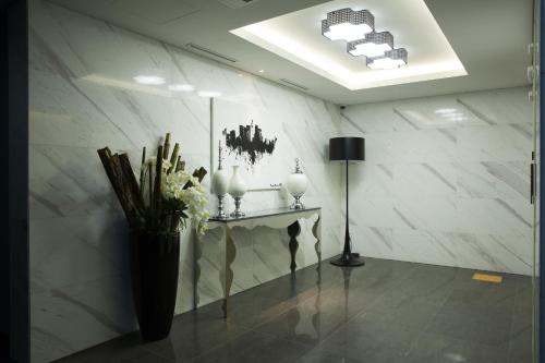 a room with a table and a vase of flowers at Hotel Mate Bundang in Seongnam