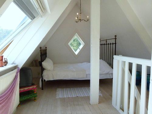 een kleine slaapkamer met een bed op zolder bij Ons Buiten in Bergen