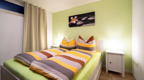a bedroom with a bed with striped pillows on it at Ferienwohnung Mittelsberg in Konstanz