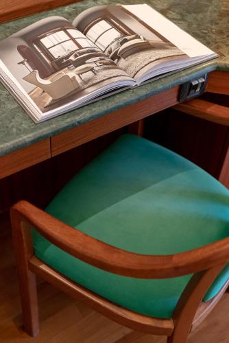 a chair sitting under a desk with an open book at Hotel Polo in Rimini