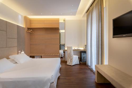 a hotel room with two beds and a flat screen tv at Hotel Polo in Rimini