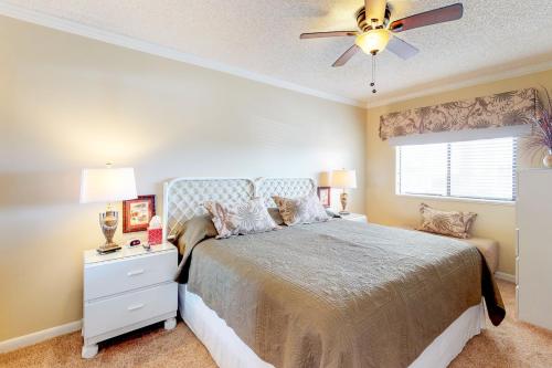 a bedroom with a bed and a ceiling fan at The Whispering Seas in Panama City Beach