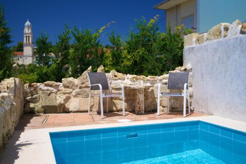 two chairs and a table next to a swimming pool at Villa Rospovi in Kaligata