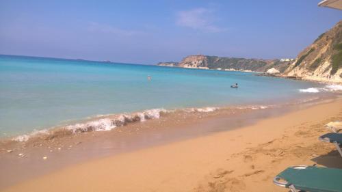 a sandy beach with a boat in the water at Villa Rospovi in Kaligata