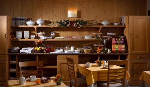 een eetkamer met twee tafels en planken met keramiek bij Hotel Sole in Malè