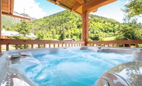 a hot tub on a deck with a mountain at Ledro Mountain Chalet in Ledro