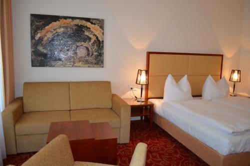 a hotel room with a bed and a couch at Hotel Jäger in Vienna