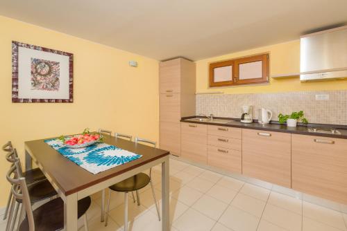 una cocina con una mesa con un bol de fruta. en Apartments Vallum, en Bol