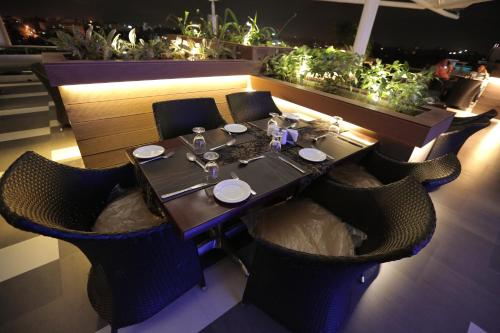 a dining table and chairs in a restaurant with plants at SP Grand Days in Trivandrum