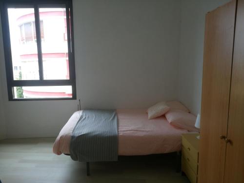 ビルバオにあるBilbao habitacionesの小さなベッドルーム(ベッド1台、窓付)