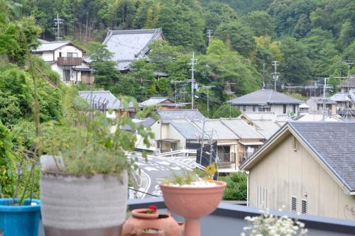 a view of a city from a balcony with potted plants at Guest House Hennka Kyoto in Kyoto
