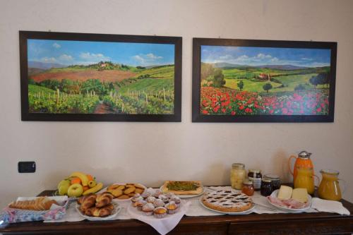 a table with food on it with paintings on the wall at B&B La Dolce Vita in Priocca
