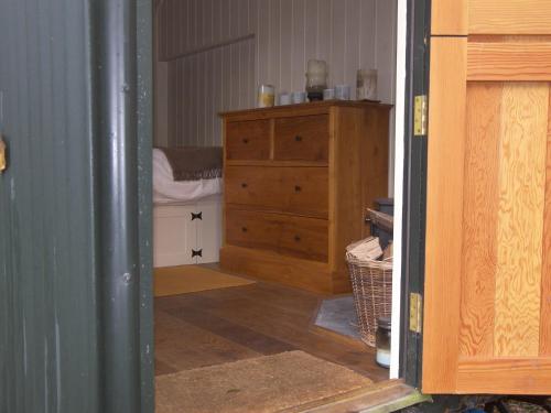 a room with a wooden dresser and a bedroom at The Hut in Ventnor